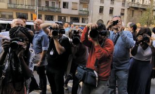 A crowd of journalists and press, pointing their cameras at the photographer