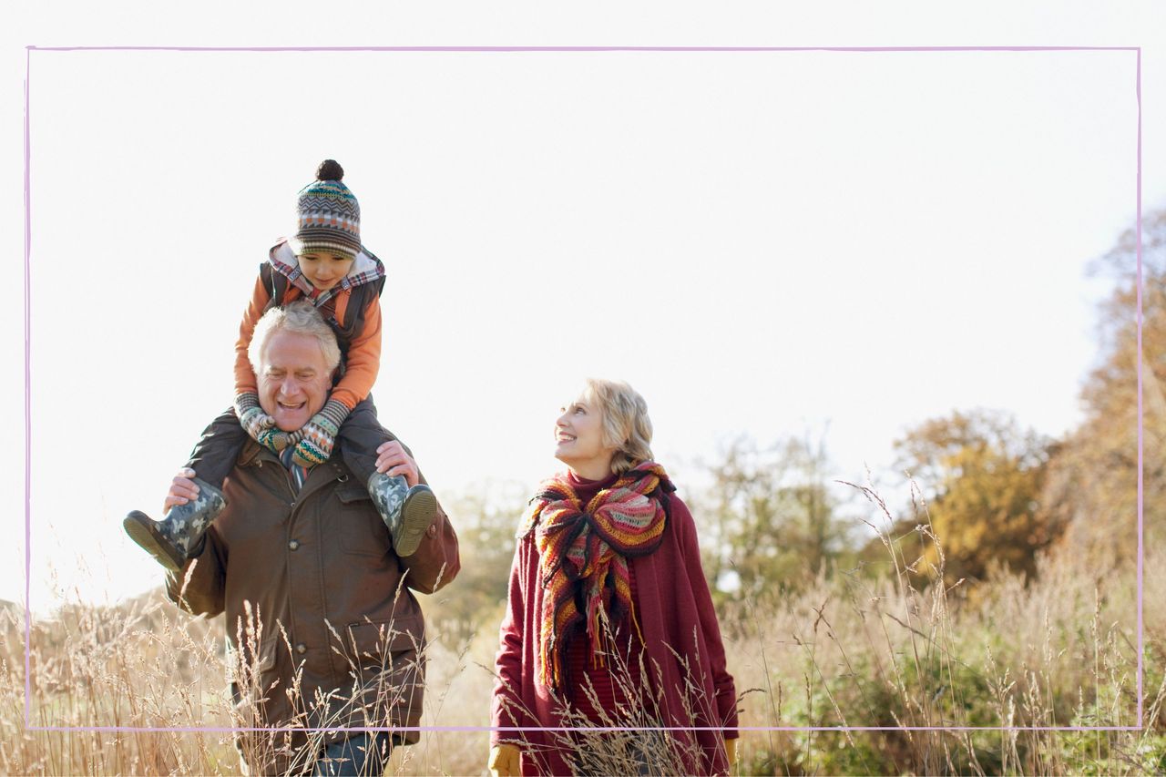 Grandparents walking outside with a young boy sitting on the man&#039;s shoulders