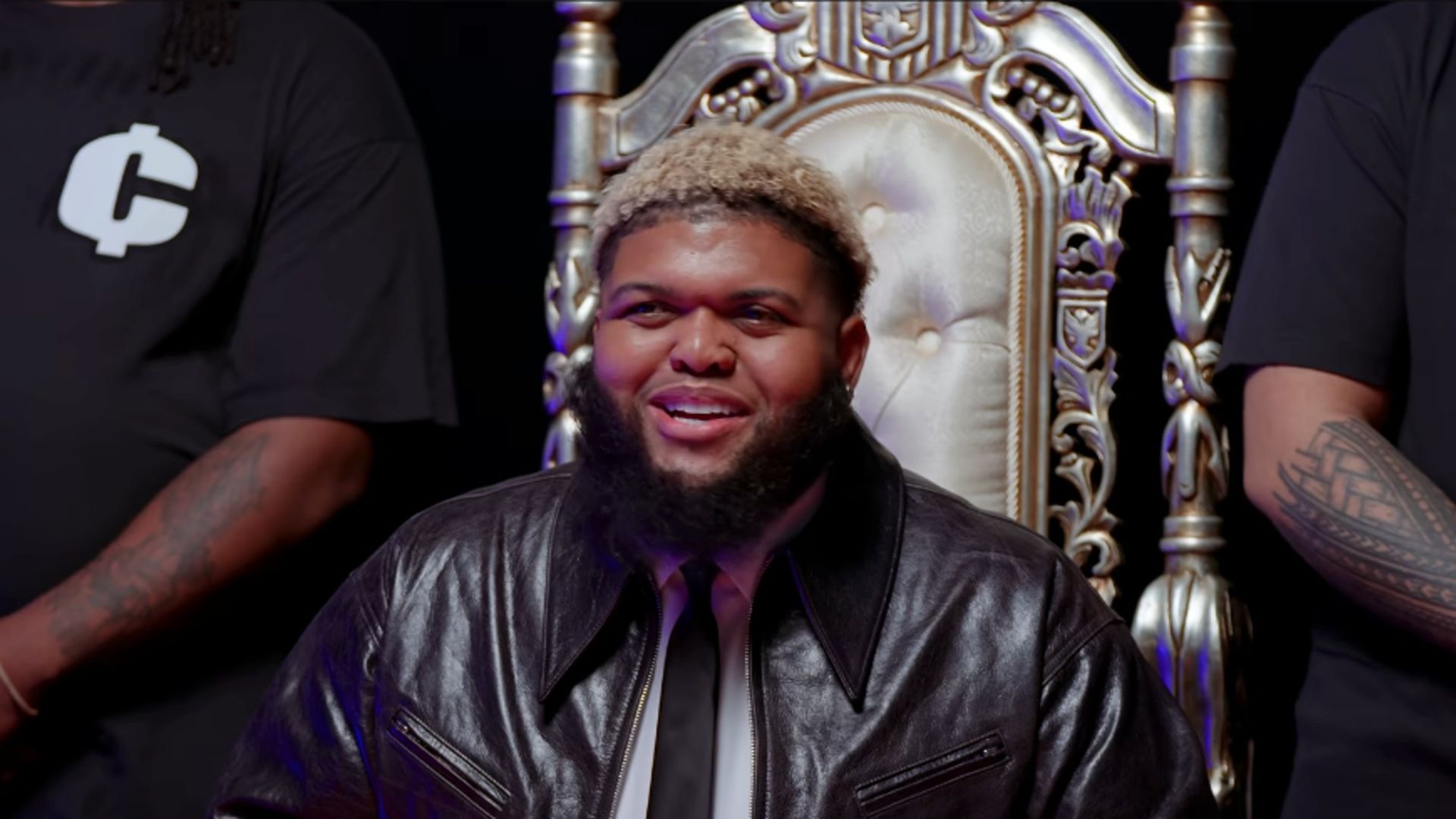 Druski with blonde hair, sitting on a throne on a skit on his YouTube channel