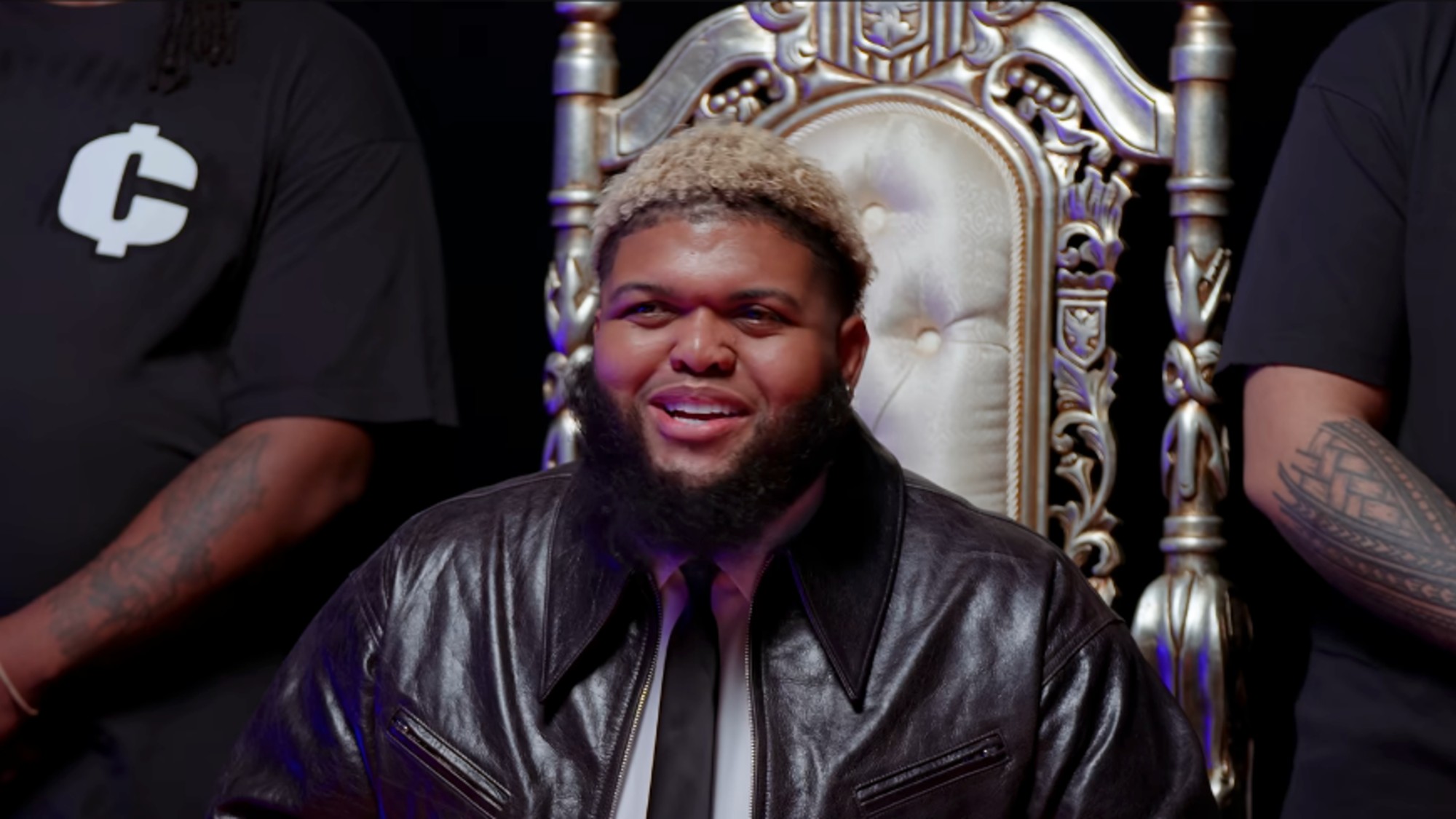 Druski with blonde hair, sitting on a throne on a skit on his YouTube channel