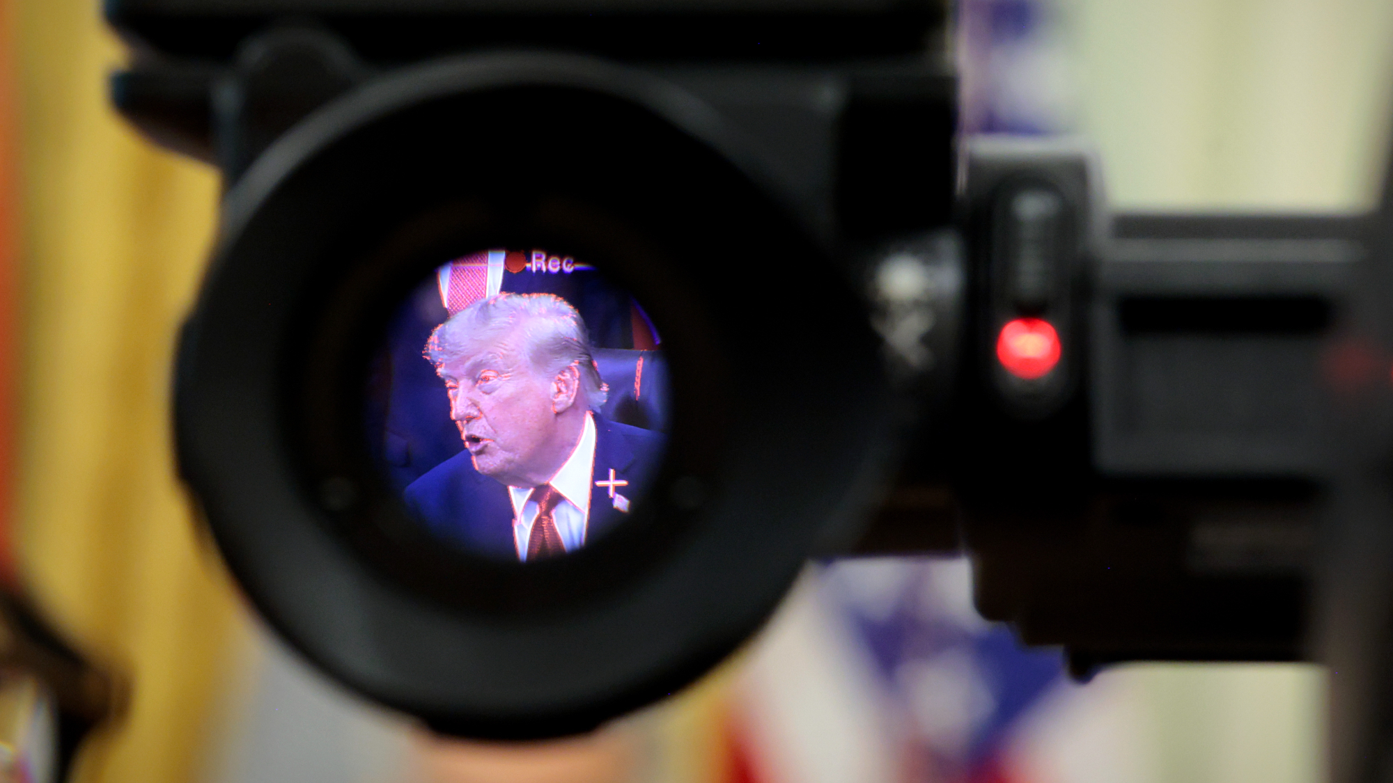 President Donald Trump is seen in the electronic viewfinder of a television camera as he speaks to reporters about healthcare in the Oval Office.