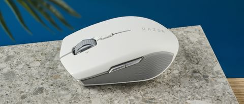 A white Razer Pro Click Mini wireless mouse on a marble slab