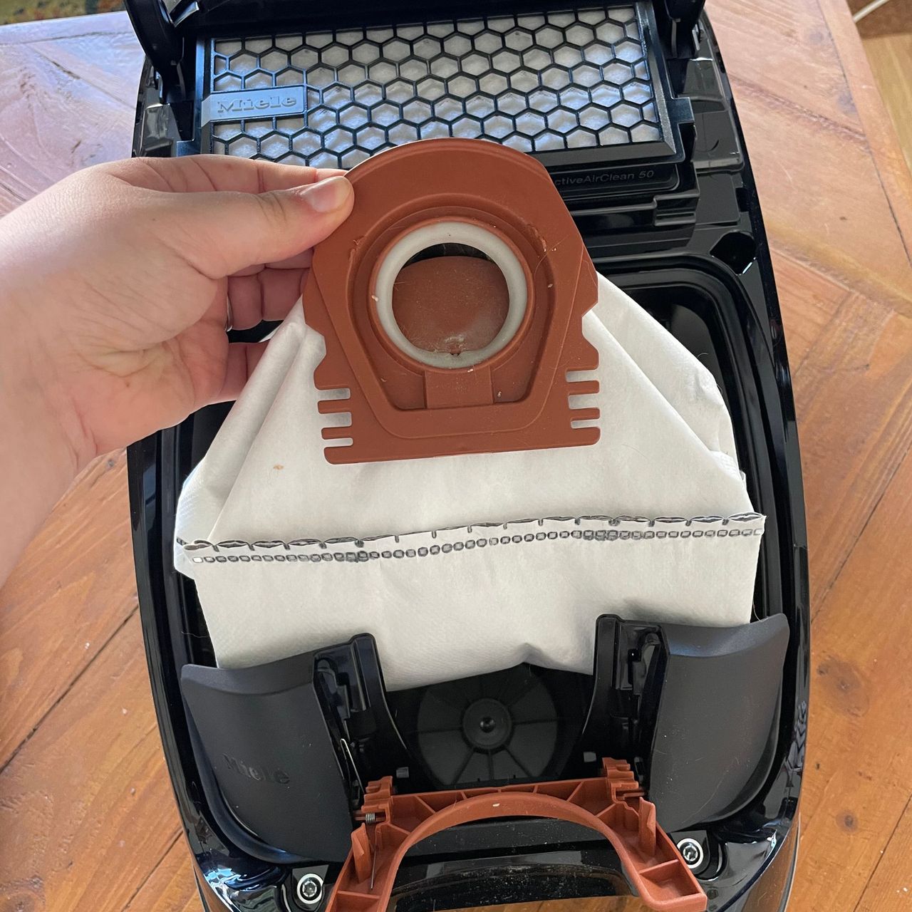 Pulling the dust bag out of the Miele Guard M1 Cat &amp; Dog vacuum