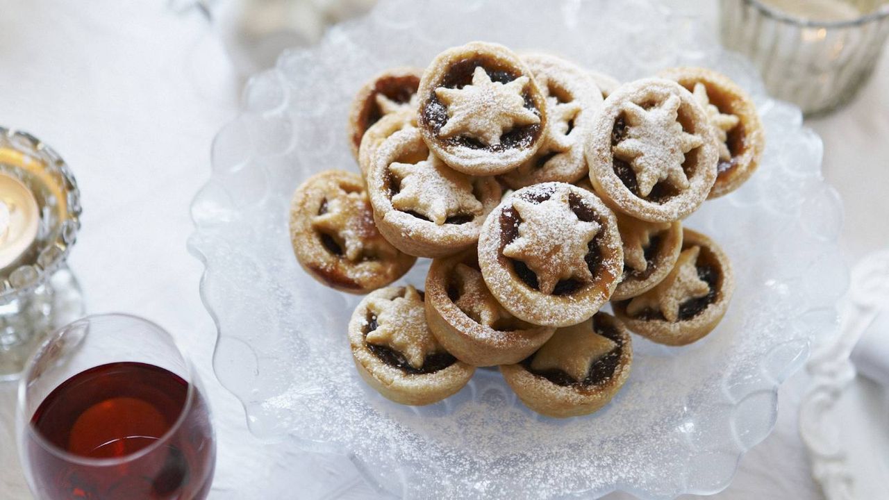 Festive table with a plate of the best mince pies and some wine 