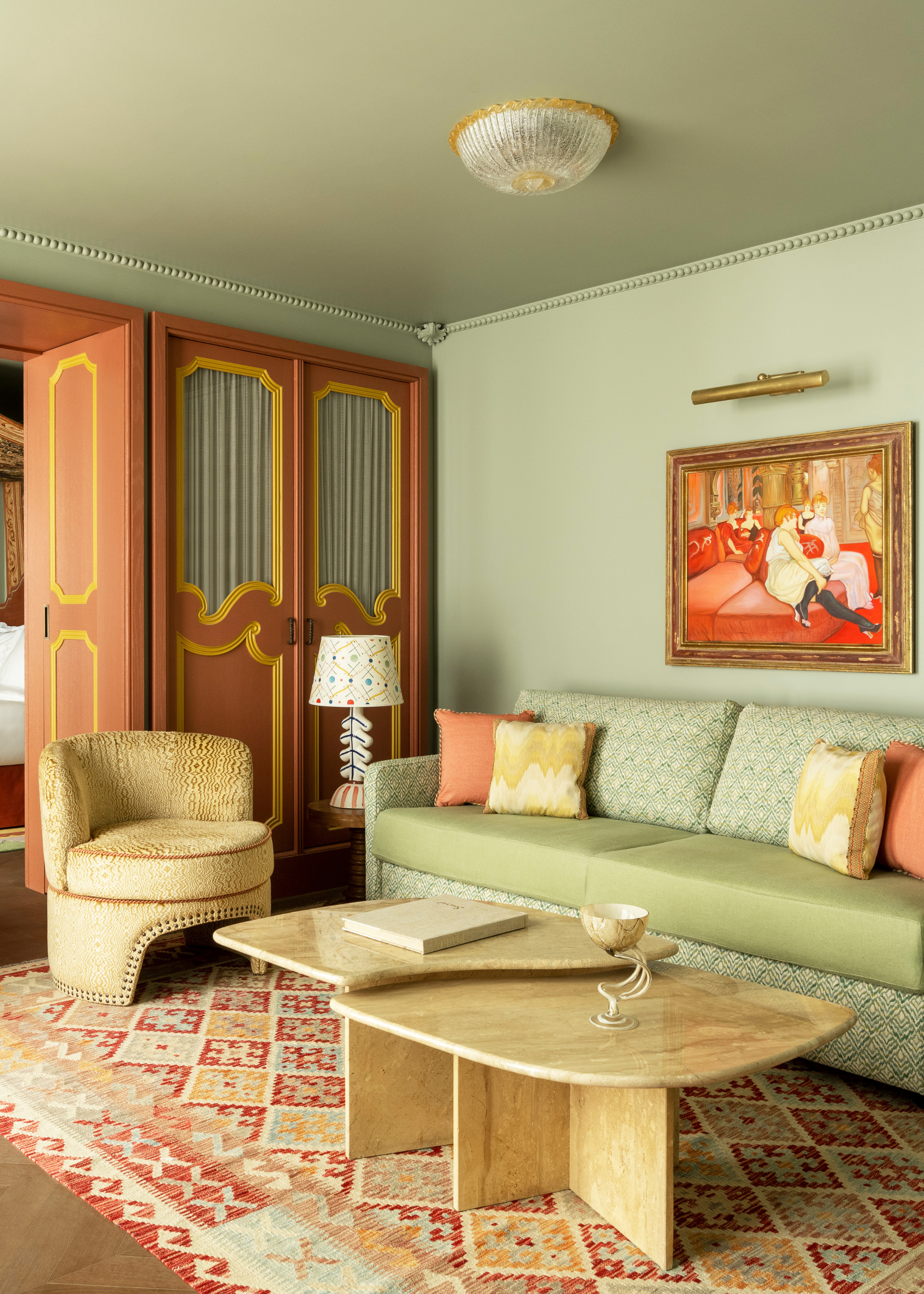 A cool grandma style living room with patterned furniture, a marble coffee table set , framed art, modern lamps, and folding colorful doors