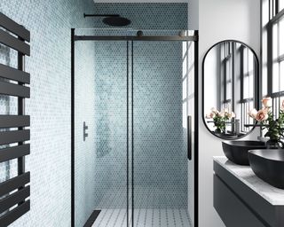 A light blue tiled bathroom with black shower cubicle