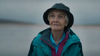 Sheila Hancock smiling, wearing a bucket hat and rain jacket