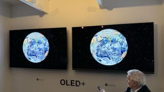 Philips OLED909 and OLED908 TVs side-by-side, with both screens showing the Earth as seen from space