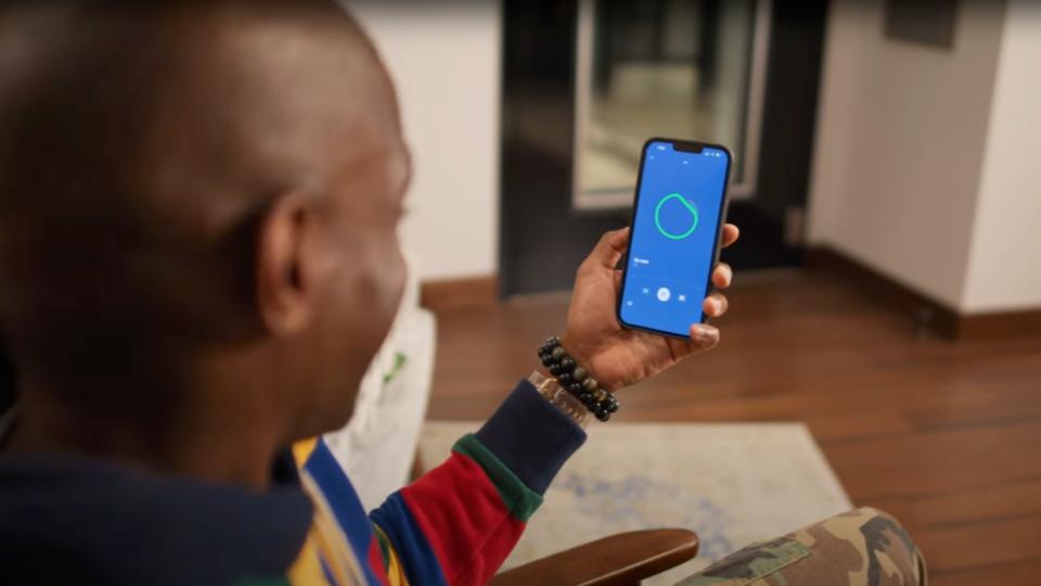 Xavier Jernigan, the voice of AI DJ, holding an iPhone with the Spotify app open