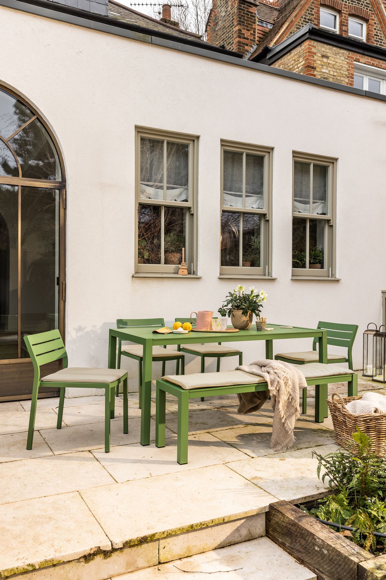 a green outdoor dining table on a patio