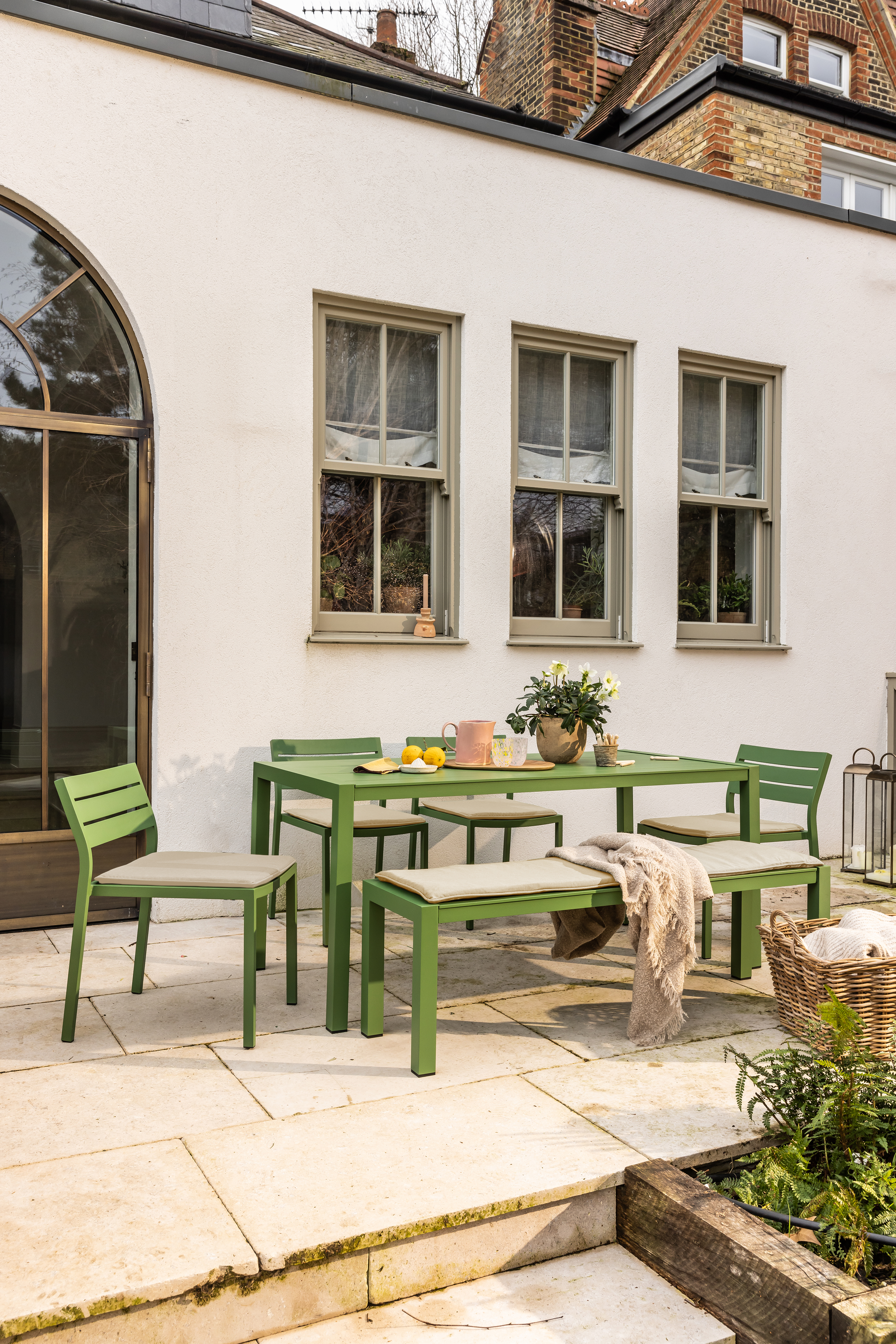 a green outdoor dining table on a patio