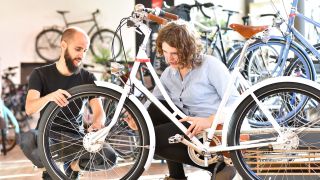 A woman and man examine a bike in a bike shop