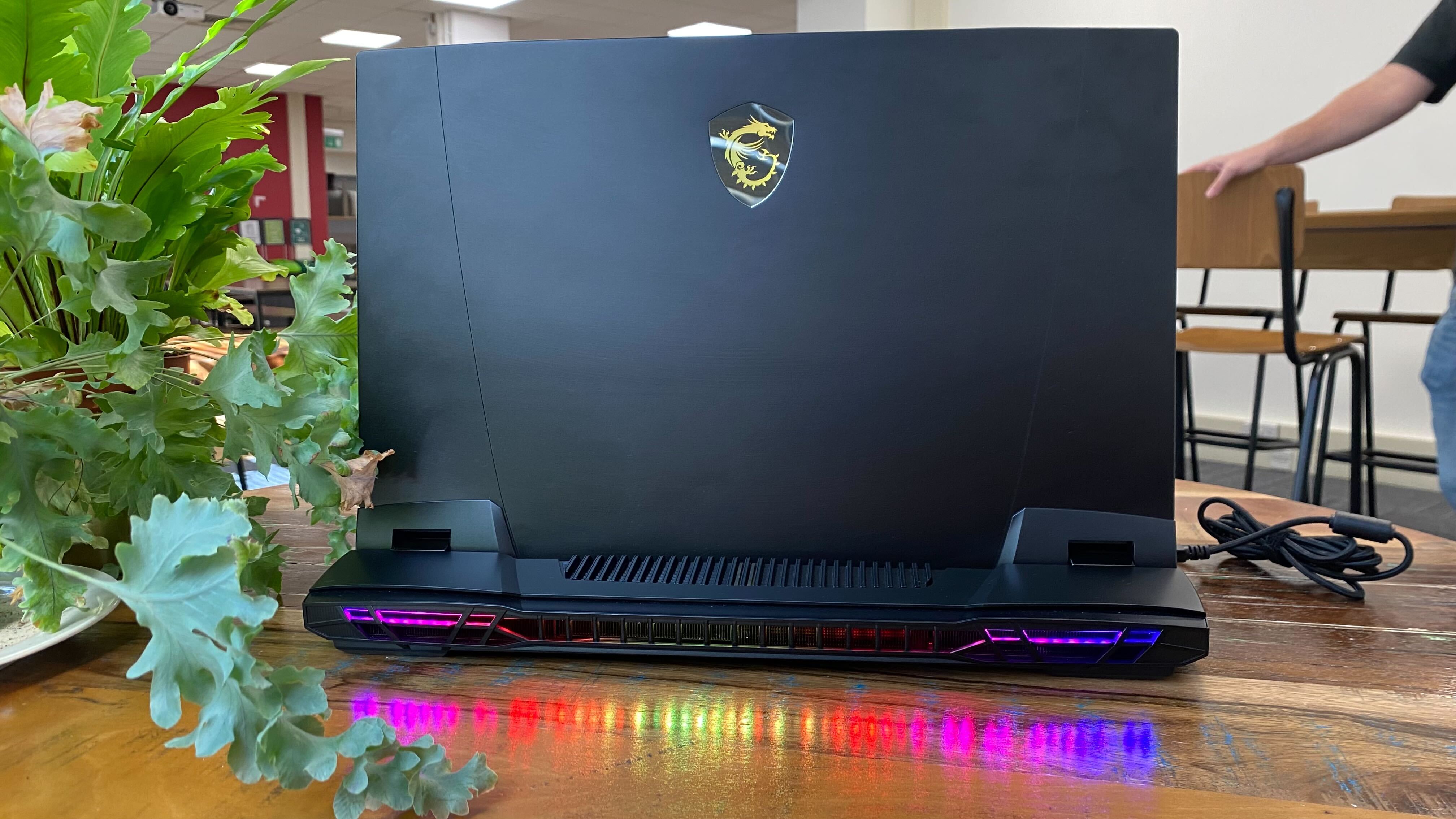 Photos of MSI GT77 on a wooden table at various angles