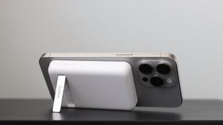 Belkin BoostCharge Magnetic Wireless Power Bank 5K + Stand with iPhone 15 Pro Max stood on its side
