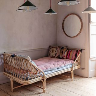 guest room daybed ideas, rattan daybed with raised ends, stripe mattress, folklore style cushions, large round mirror, pendant lights
