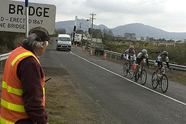 A road-worker watches a small breakaway trio escape the peloton's clutches early into the second stage.