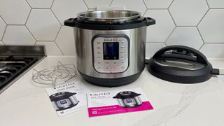 The Instant Pot Duo Nova on a kitchen countertop surrounded by its accessories