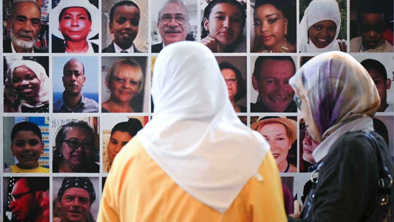 Menana Jabari (left), who lost her daughter and grandchildren in the Grenfell Tower fire, looks at a wall displaying pictures of the 72 people killed in the blaze, at a press conference at the Royal Lancaster Hotel in London following the publication of the Grenfell Tower Inquiry