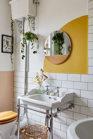 bathroom basin with a yellow sunshine paint effect on the wall