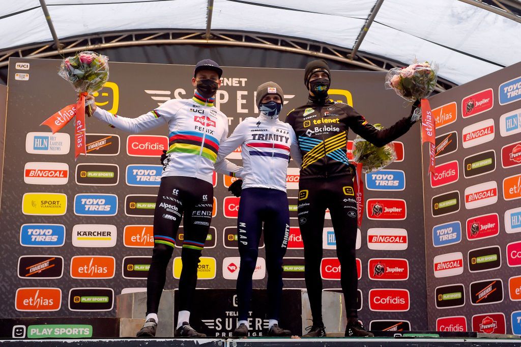 ANTWERPEN BELGIUM DECEMBER 13 Podium Mathieu Van Der Poel of The Netherlands and Team AlpecinFenix Thomas Pidcock of United Kingdom Team Trinity Racing Toon Aerts of Belgium and Team Telenet Baloise Lions Celebration Mask Covid safety measures Flowers during the 43rd Superprestige Cyclocross Gavere 2020 Men Elite Superprestige2021 SPGavere SuperprestigeCX on December 13 2020 in Antwerpen Belgium Photo by Luc ClaessenGetty Images