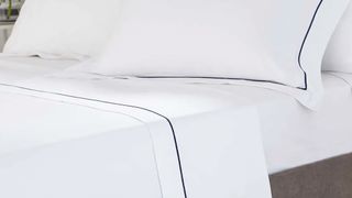 White bedding with navy blue pipe detail on duvet set with best white sheet