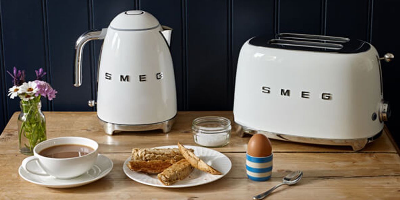 Image of Smeg toaster and kettle set in promoational image on table with tea and bread 