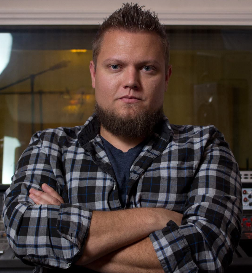 Headshot of Josh Carney with folded arms.