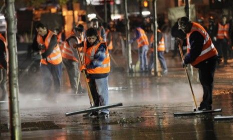 Workers clean up Zuccotti Park after New York City police remove Occupy Wall Street protesters on Mayor Michael Bloomberg&amp;#039;s orders early Tuesday morning.