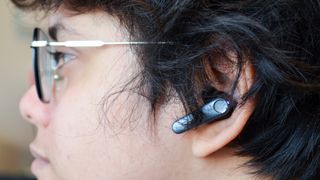 A close-up shot of a person wearing an EarFun Air Pro 3 wireless earbud in the left ear.