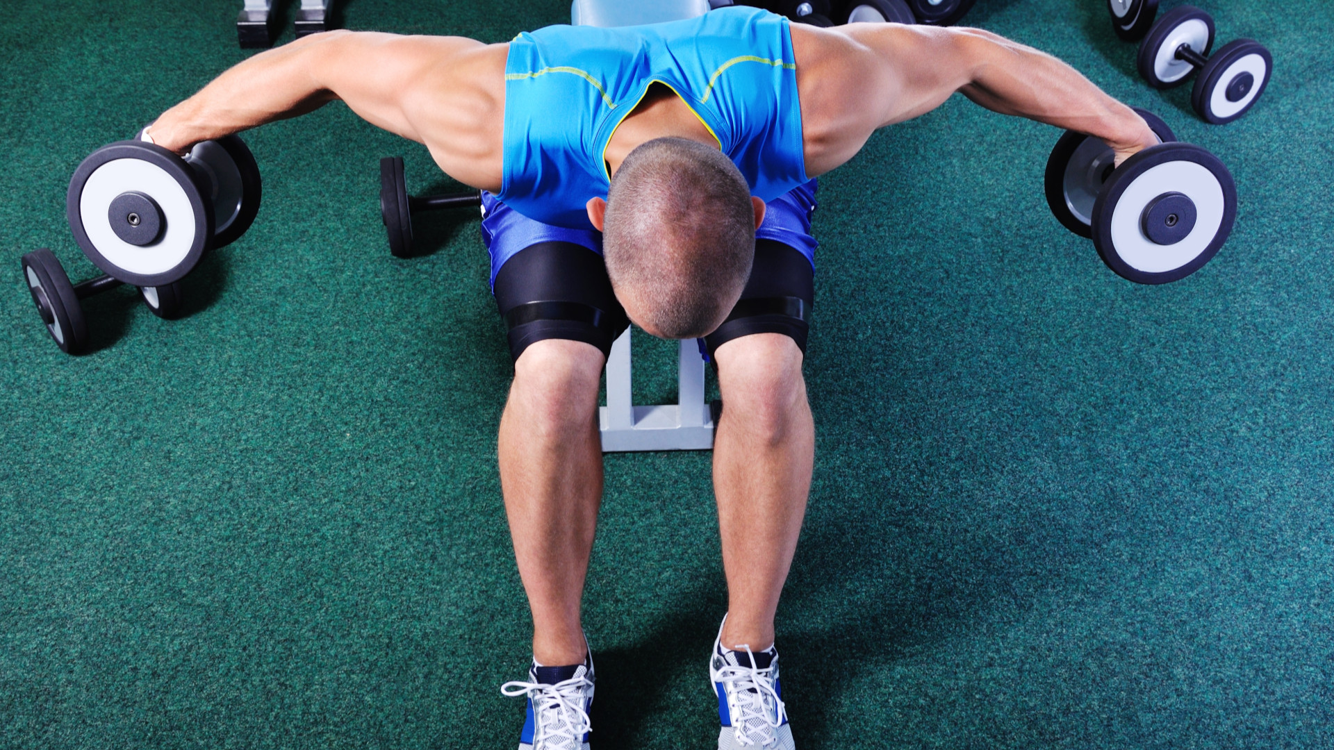 A man performing reverse dumbbell flyes