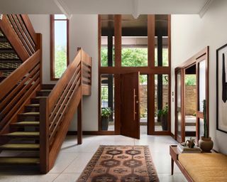 An entryway with tall ceilings and a large wooden staircase