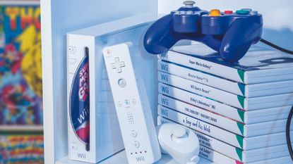 A picture of the Nintendo Wii and a stack of games with a GameCube controller on top of the game pile. 