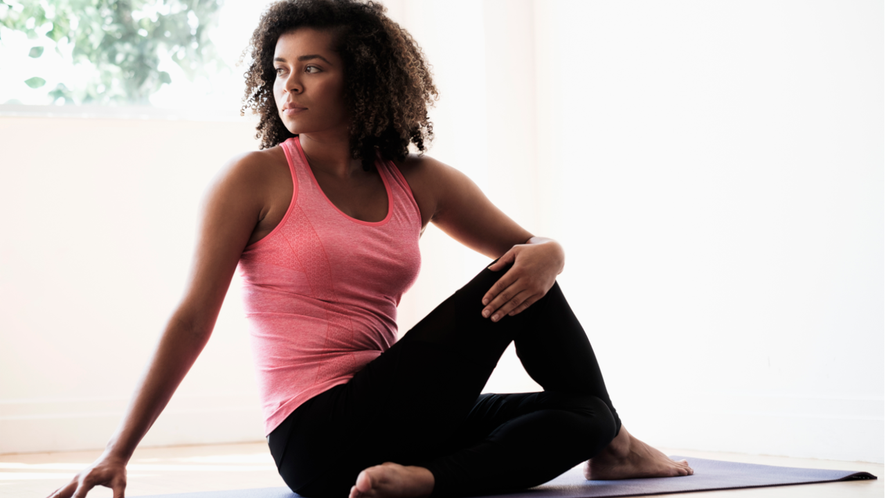 Woman doing a back stretch sat on the floor