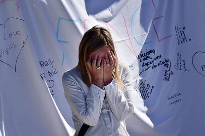 A woman cries in front of a memorial in Nice