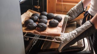 Someone pulling burnt baked goods out of an oven