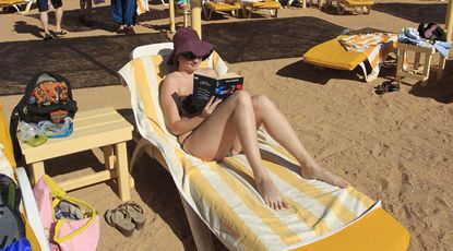 A holidaymaker reads a book