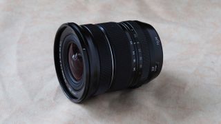 Fujinon XF 10-24mm f/4 R OIS WR camera lens on a marbled surface