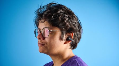 Skullcandy Push 720 Open in black and silver colorway with charging case photographed on a blue background