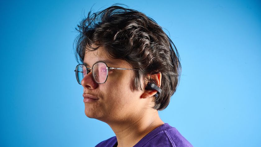 Skullcandy Push 720 Open in black and silver colorway with charging case photographed on a blue background