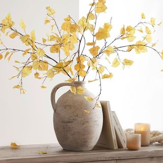 Faux Autumn Aspen Tree Branch in a vase against a white background.