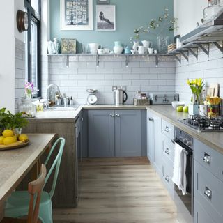 grey kitchen with fairy lights under open shelves