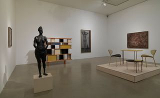 An exhibition hall with table and chair and a statue