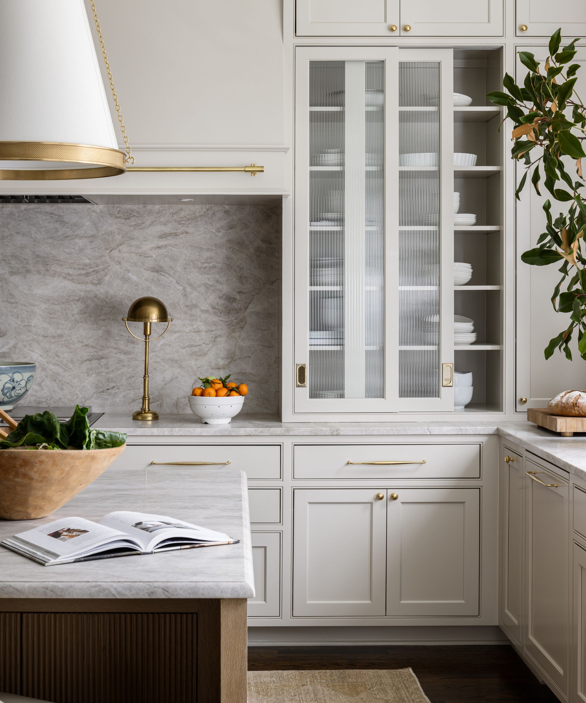 modern kitchen with pale gray cabinets and brass hardware