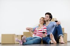 A young couple with wine and moving boxes.
