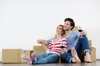 A young couple with wine and moving boxes.