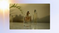 A stock image of three glass perfume bottles sitting on a dresser in sunlight/ in a blue template with a yellow and pink sun effect.