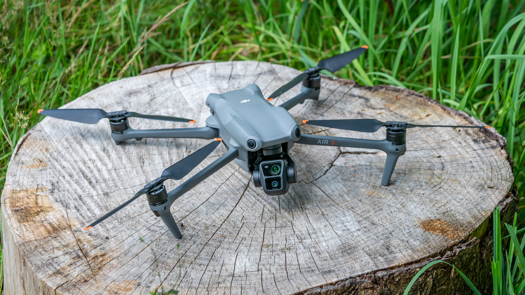 DJI Air 3 drone on a tree stump with arms and propellors in flight position