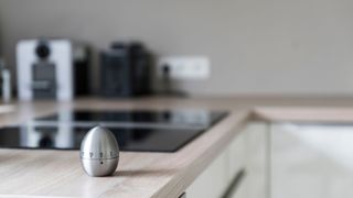 An egg timer beside a hob