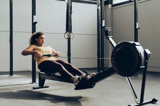 A woman on a rowing machine at a fitness studio