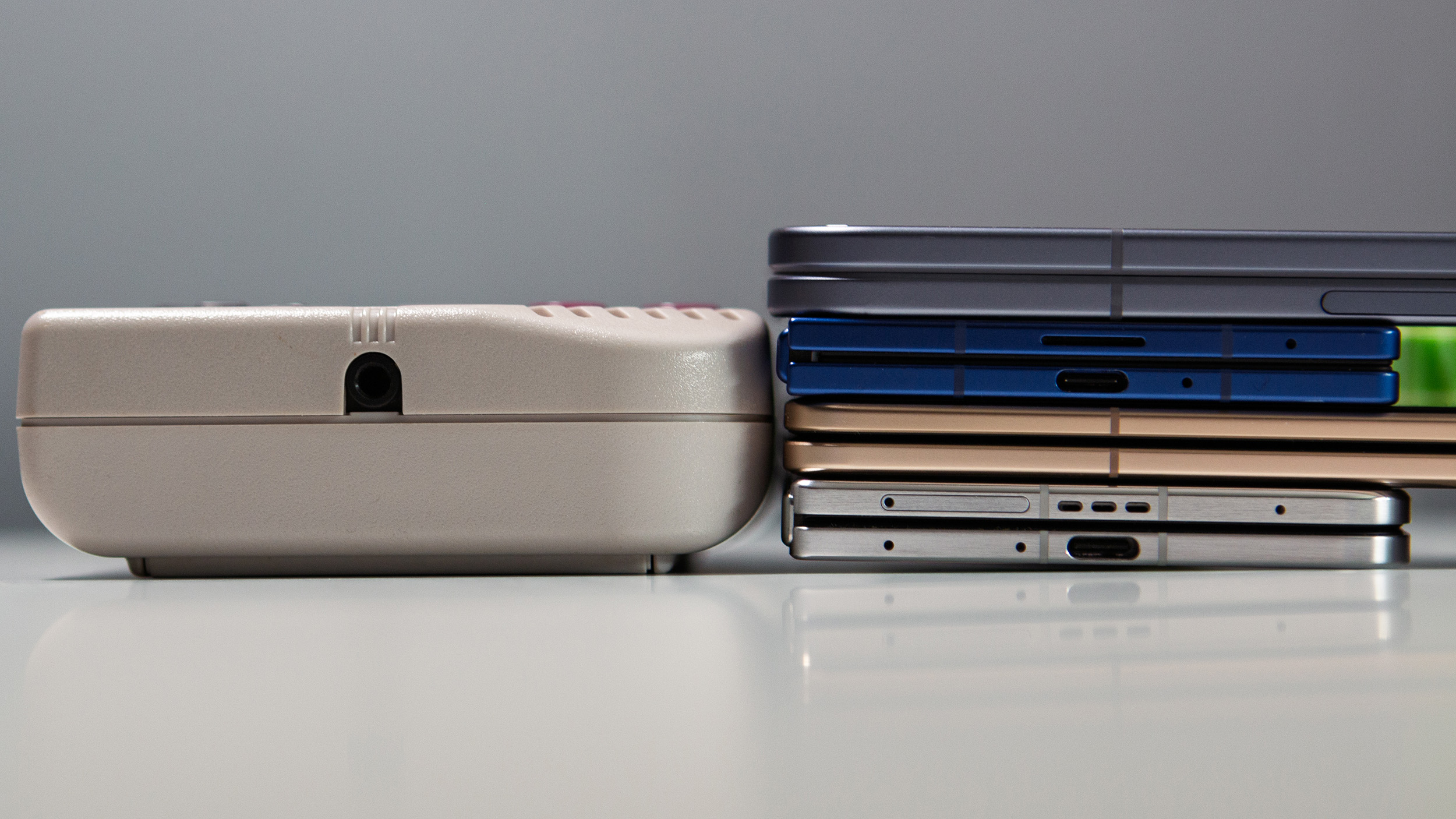 Pixel 10 Pro Fold, Honor Magic V5, Samsung Galaxy Z Fold 7, Oppo Find N5 stacked next to original Game Boy DMG